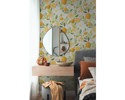 Ložnice s tapetou na stěně zdobenou citrony a květinovými motivy, doplněná zrcadlem, plovoucí policí a postelí.