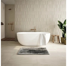 Moderní koupelna s volně stojící vanou, strukturovanými obkládačkami a dřevěnými prvky.