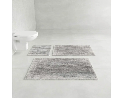 Šedá sada koupelnových předložek v koupelně vedle toalety