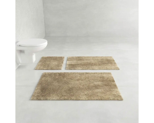 Koupelna s toaletní mísou a třemi koupelnovými předložkami