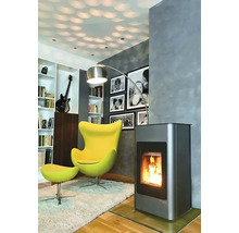 Obývací pokoj s kamny, křeslem, stojací lampou a knihovnou