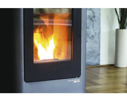 Detailní pohled na kamna na pelety s hořícím ohněm za sklem a logem Haas und Sohn