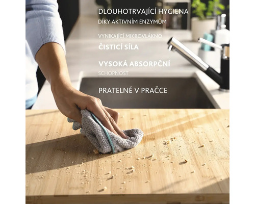 Osoba čistí prkénko hadříkem. Hadřík je šedý s barevným pruhem.