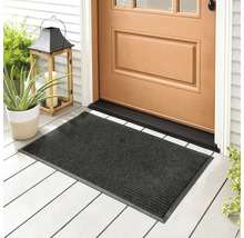 Šedá rohožka před vchodovými dveřmi na verandě s rostlinami a lucernou