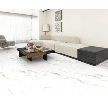 Světlý obývací pokoj s pohovkou, konferenčním stolkem a dlažbou.