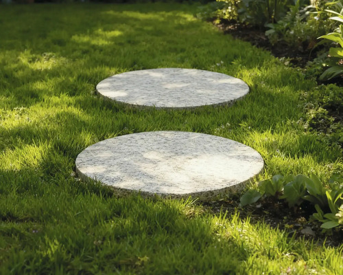 Dva kulaté kamenné nášlapné kameny v trávníku