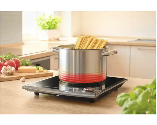 Nerezový hrnec se špagetami na indukční varné desce v kuchyni