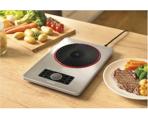 Indukční varná deska Sencor se zeleninou a steakem na dřevěném stole