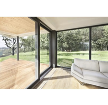 Světlý obývací pokoj s velkým oknem a výhledem do zeleně