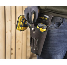 Řemeslník s pásem na nářadí Stanley s vrtačkou a laserovým dálkoměrem