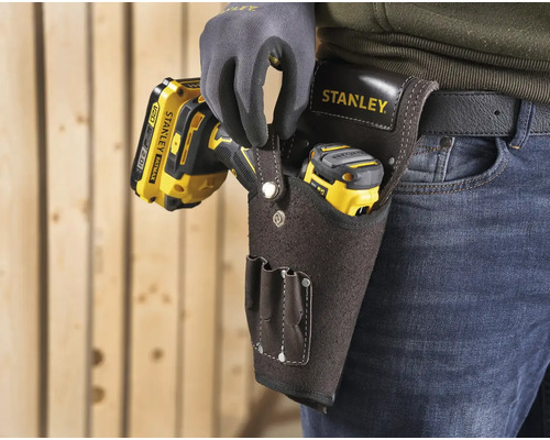 Řemeslník s pásem na nářadí Stanley s vrtačkou a laserovým dálkoměrem