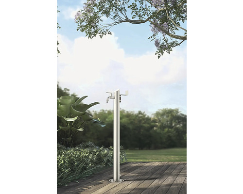 Zahradní scéna s volně stojícím kovovým vodním sloupkem na dřevěné terase