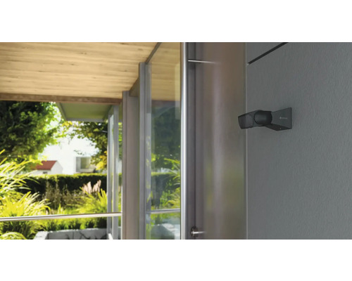 Venkovní reflektor na stěně domu s výhledem do zahrady