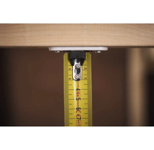 Žlutý svinovací metr s přišroubovaným upevněním na dřevo