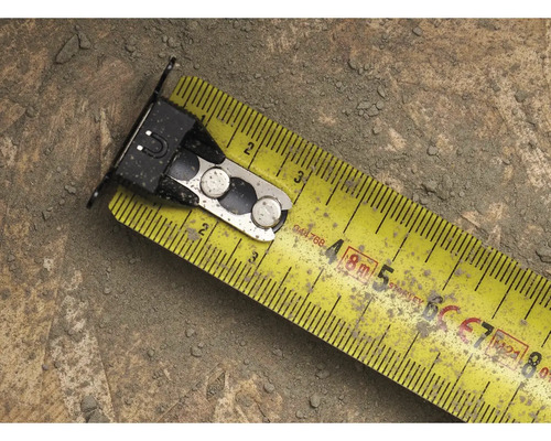 Žlutý svinovací metr s kovovými prvky na povrchu