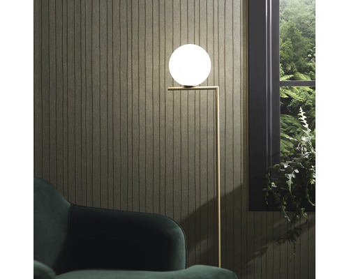 Stojací lampa s kulovitým stínidlem vedle okna a křesla.