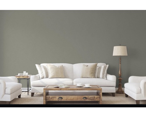 Obývací pokoj s pohovkou, křeslem, stolem a stojací lampou před barevnou stěnou