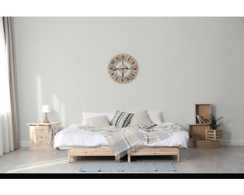 Ložnice s manželskou postelí, dřevěné bedny, stolní lampa a nástěnné hodiny