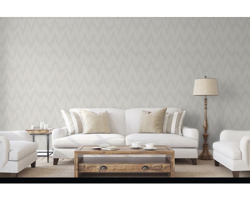 Obývací pokoj s tapetou se vzorem cikcak, pohovka, křesla, stůl a stojací lampa pro světlou a příjemnou atmosféru.