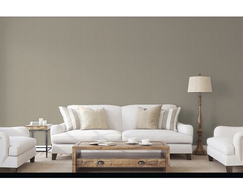 Obývací pokoj s pohovkou, křeslem, konferenčním stolkem a stojací lampou před strukturovanou tapetou