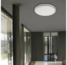 Pohled na pokoj s kulatým stropním svítidlem s křišťálovým okrajem