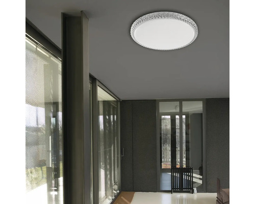 Pohled na pokoj s kulatým stropním svítidlem s křišťálovým okrajem