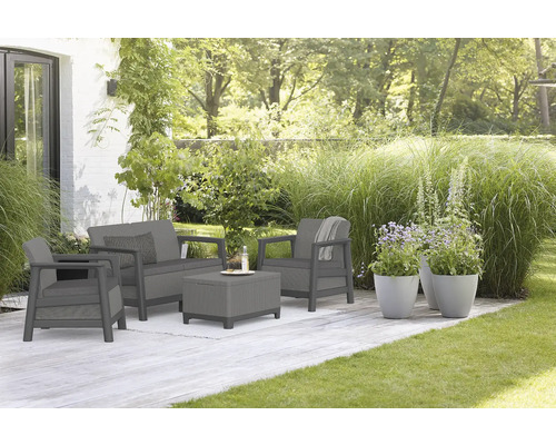 Zahradní sedací souprava s pohovkou, křeslem a stolem na terase