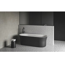 Volně stojící vana v moderní koupelně s teracovou podlahou a stěnou