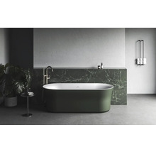 Volně stojící vana v koupelně s mramorovou policí a držákem na ručníky