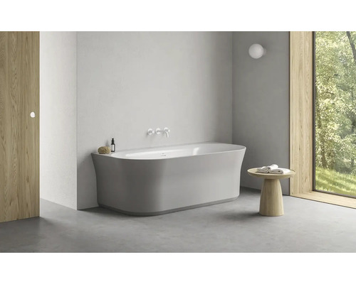 Moderní koupelna s volně stojící vanou, dřevěným stolem a oknem