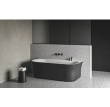 Volně stojící vana v moderní koupelně s teracovou podlahou a obkladem stěn