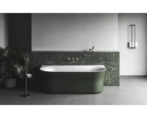 Volně stojící vana v světlé koupelně s armaturami a držákem na ručníky.