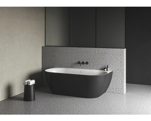 Volně stojící vana v moderní koupelně s taburetem na ručníky