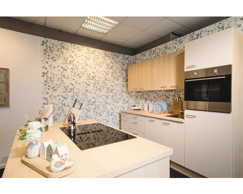 Světlá kuchyně s kuchyňským ostrůvkem, vestavěnou troubou a květinovou tapetou