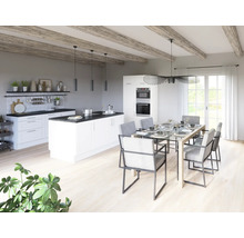 Světlá kuchyně s varným ostrovem, jídelním stolem a židlemi v prostorné místnosti.