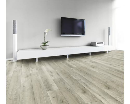 Obývací pokoj se světlou dřevěnou laminátovou podlahou, bílou nízkou skříňkou, televizí a reproduktory