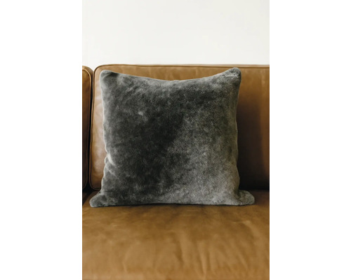 Dekorační polštář z umělé kožešiny na pohovce