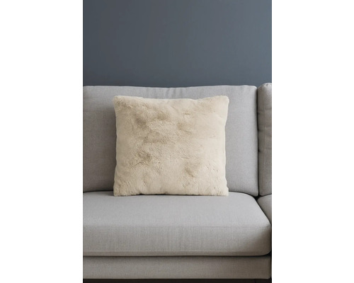 Dekorační polštář z umělé kožešiny na pohovce