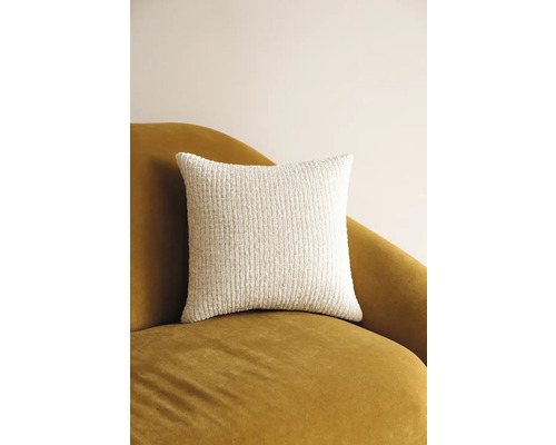 Čtvercový dekorativní polštář ze strukturované látky na křesle