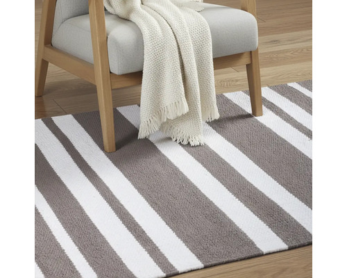 Pruhovaný koberec s křeslem a dekou