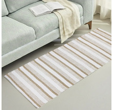 Koberec s pruhovaným vzorem vedle pohovky s otevřenou knihou