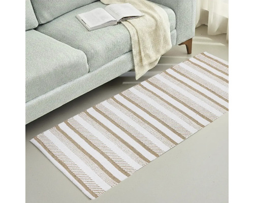 Koberec s pruhovaným vzorem vedle pohovky s otevřenou knihou