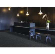 Scéna s tmavým kobercem, pultem, stoličkami a osvětlením pro moderní kancelářské prostředí.