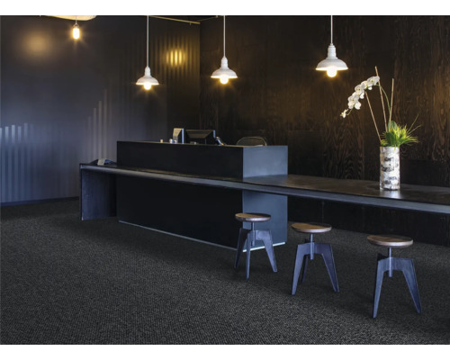 Scéna s tmavým kobercem, pultem, stoličkami a osvětlením pro moderní kancelářské prostředí.