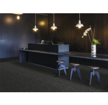 Recepce s kobercem, stolem a barovými stoličkami pod závěsnými lampami