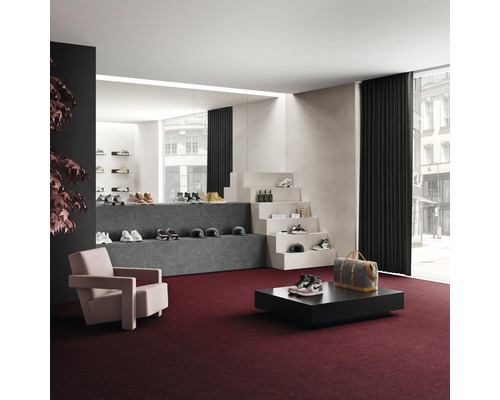 Interiér s kobercem, křeslem, stolem a prezentací obuvi a doplňků