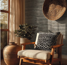 Dekorativní obývací pokoj s dřevěnou židlí, polštářem, rostlinou a velkým džbánem