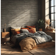 Ložnice s postelí na dřevěném pódiu, polštáře a dekorace