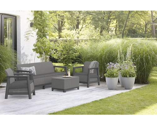 Zahradní sedací souprava na terase s pohovkou, křeslem a stolem venku.