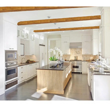 Světlá kuchyně s kuchyňským ostrovem, vestavěnými skříněmi a dřevěnými trámy